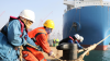 Workers untie the cables at a dock in Qingdao, China. The vast majority of Canada's at-risk imports of electronics are from China, with Malaysia a distant second. March 10, 2023.