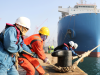 Workers untie the cables at a dock in Qingdao, China. The vast majority of Canada's at-risk imports of electronics are from China, with Malaysia a distant second. March 10, 2023.