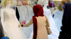 Iraqi women look at wedding gowns outside a bridal shop