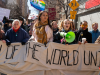 Demonstrators hold signs during a march honoring International Women's Day March 8, 2025 in New York City.