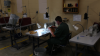 A prisoner works sewing uniforms while serving her sentence at a 